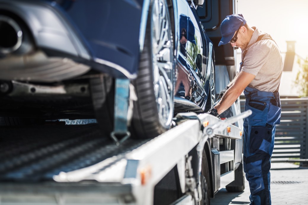 A Getsemani driver securing a car to the carrier before transport